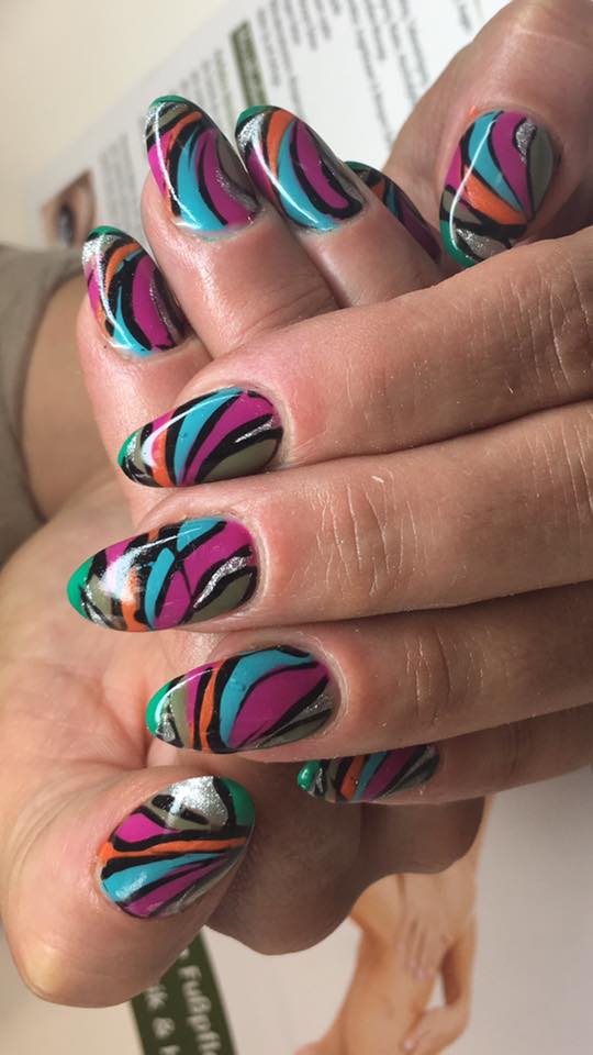 Buntes Nageldesign mit mehreren Farben und Motiven